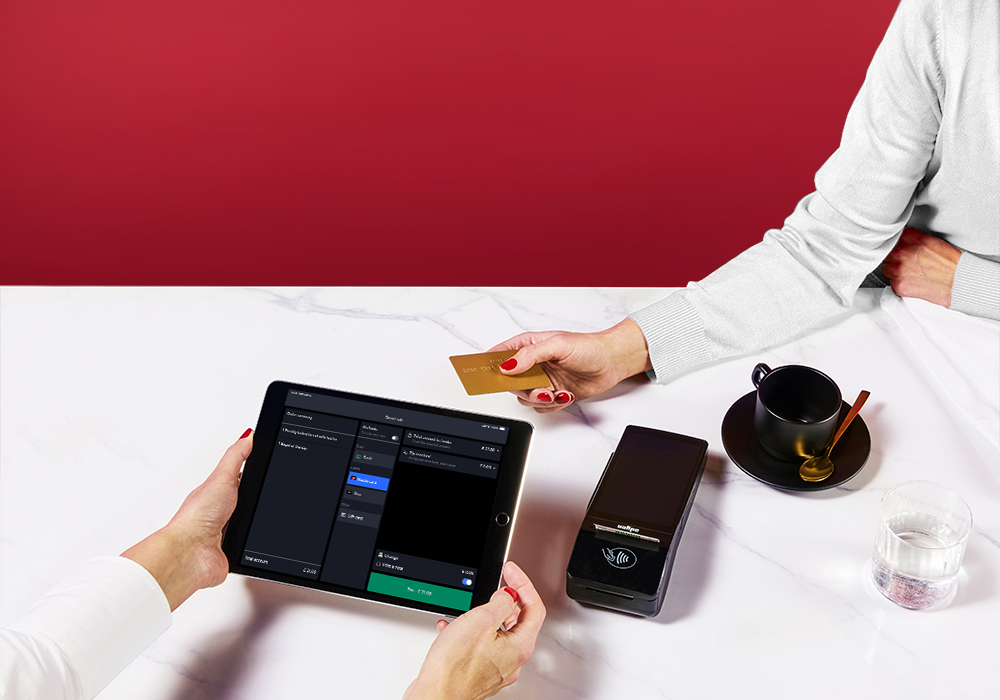 iPad interface van Lightspeed's horeca kassasyteem met betaalterminal, kopje koffie en glas water.