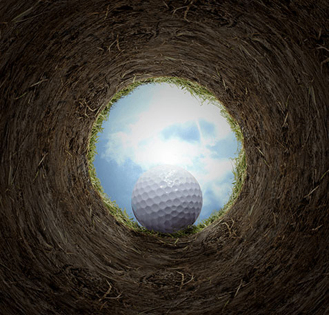 Golf ball going into hole