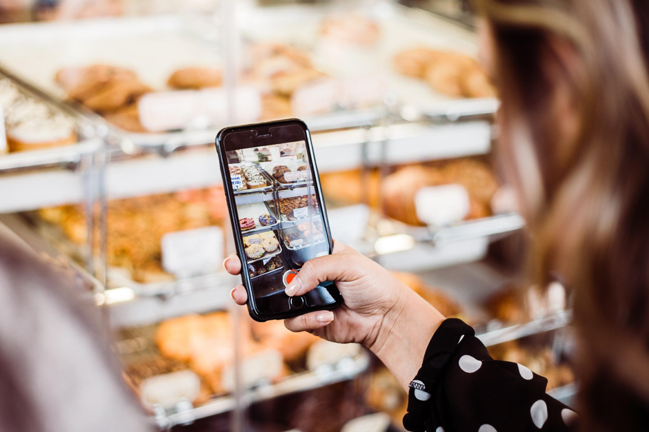 Vrouw neemt een foto van het assortiment met een mobiele telefoon