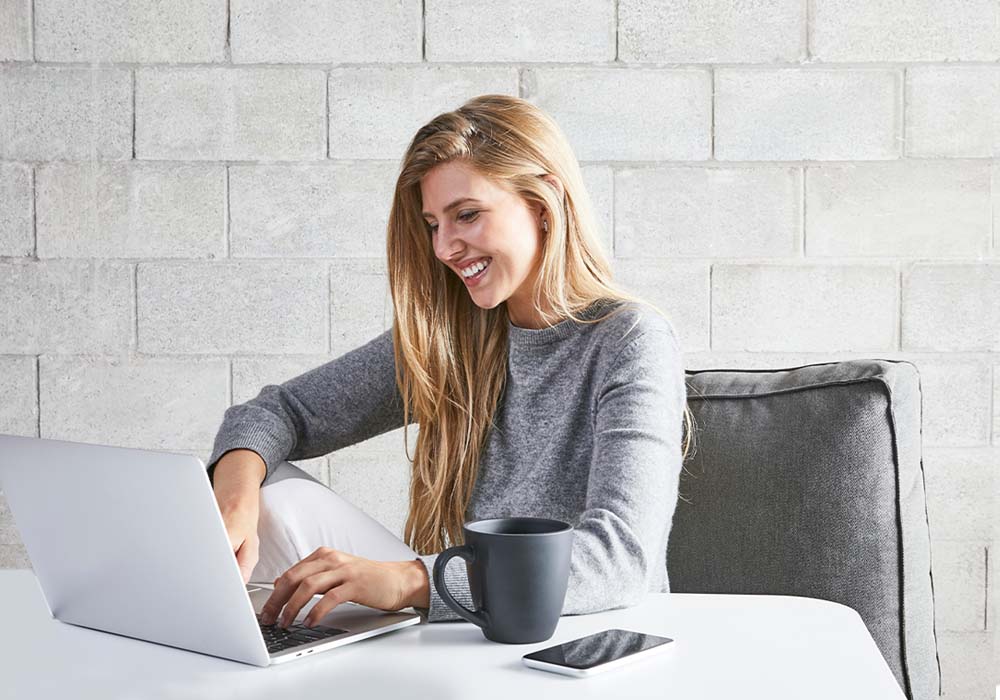 Persoon kijkt lachend naar laptop