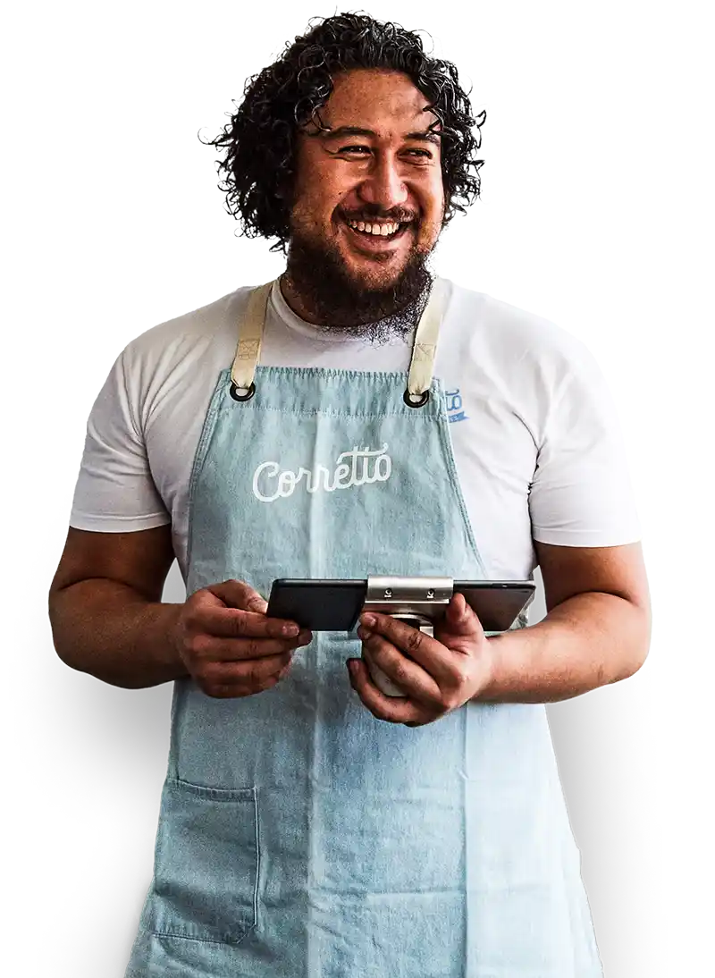 Glimlachende restauranteigenaar in een wit t-shirt en schort gebruikt het Lightspeed horeca kassasysteem op een tablet.