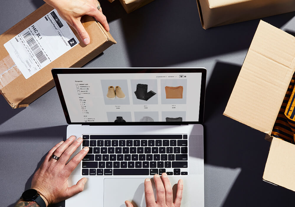 Een doos met daarnaast een laptop met een pagina van een kleding webshop open